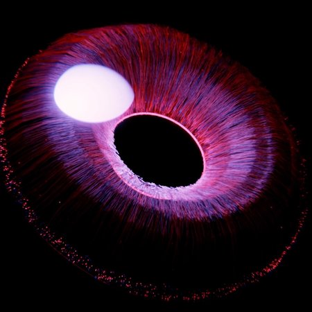 Magnetische Plasmaerscheinung Eine abstrakte Darstellung mit einer farbenfrohen, kreisförmigen Struktur, die von radialen Linien umgeben ist. In der Mitte befindet sich ein kleiner, heller Kreis auf dunklem Hintergrund, der eine dynamische, energetische Wirkung erzeugt.